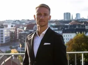 Man som står på balkong finklädd